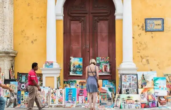 Turistas frente a una exhibición de arte al aire libre en Cartagena, ideal para quienes buscan experiencias culturales en un bus city tour.